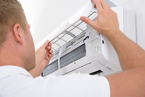 Air conditioning technician servicing an air conditioning system